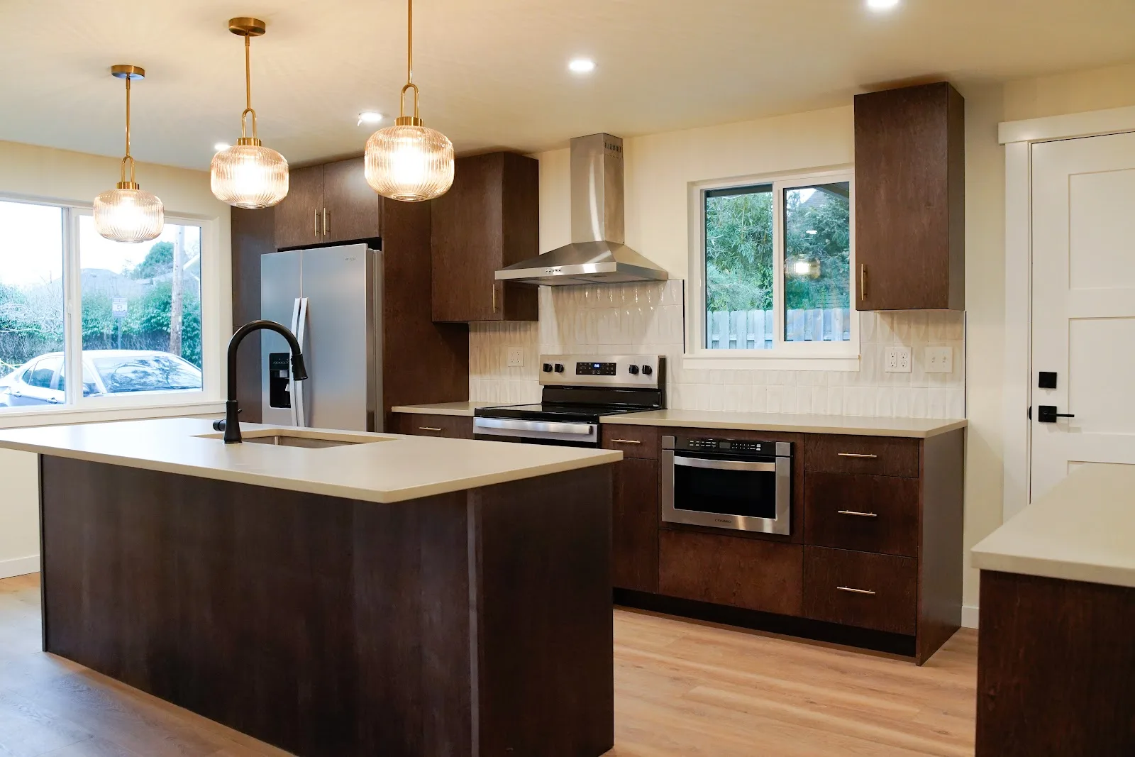 Kitchen and bath remodel with stained cabinetry, quartz island and a tiled fireplace wall in Bellingham, WA — Living By Design (3)